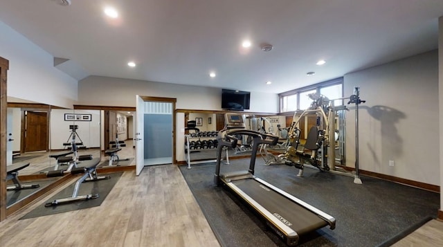 exercise room with baseboards, vaulted ceiling, wood finished floors, and recessed lighting