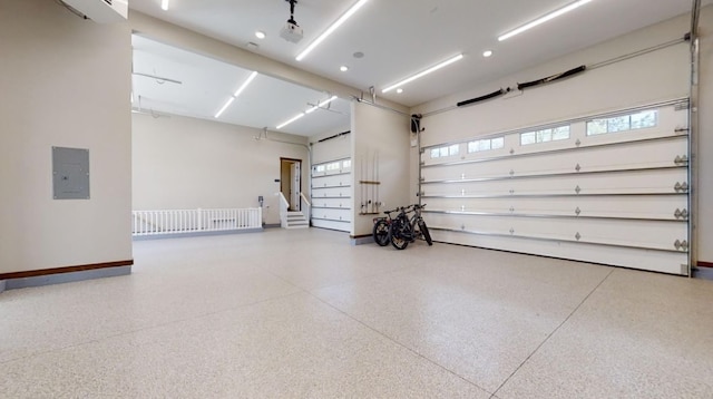 garage featuring electric panel and baseboards