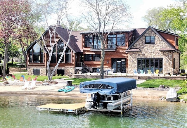 dock area featuring a patio area, a water view, and a balcony