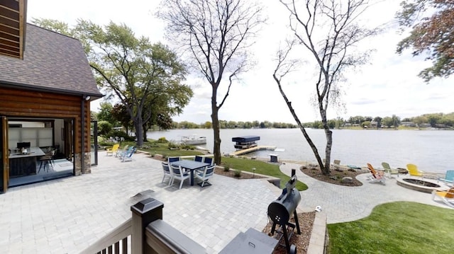 view of patio / terrace with a water view, a dock, a fire pit, and outdoor dining space