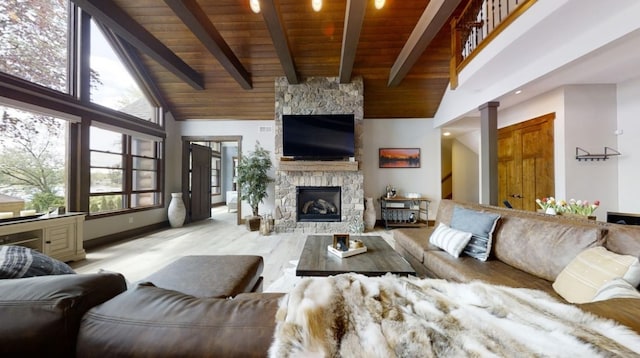 living area with beam ceiling, a stone fireplace, wood finished floors, high vaulted ceiling, and wooden ceiling