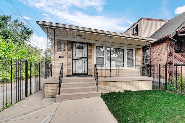 view of front facade with fence, a porch, and brick siding