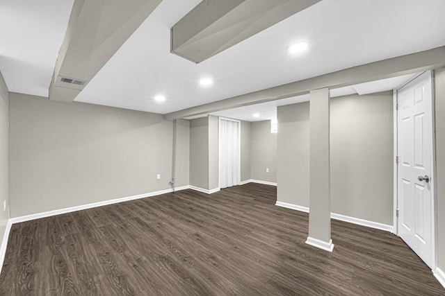 finished below grade area with dark wood-type flooring, recessed lighting, visible vents, and baseboards