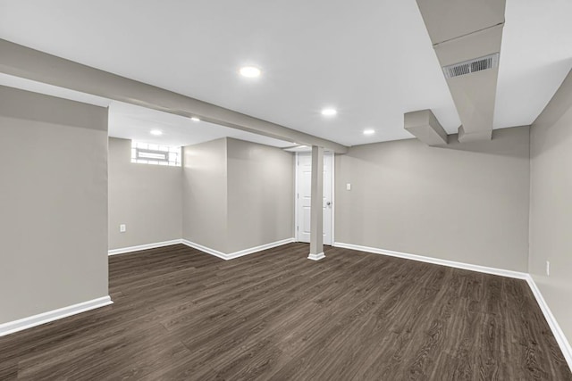 basement with dark wood-style flooring, recessed lighting, visible vents, and baseboards