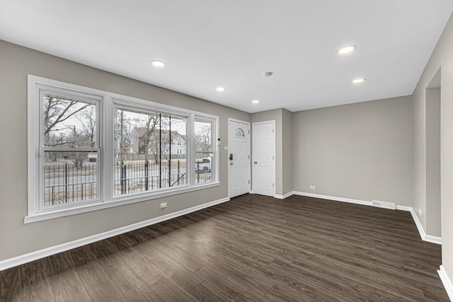 spare room featuring dark wood-style flooring, recessed lighting, visible vents, and baseboards