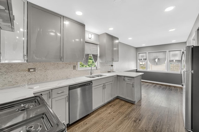 kitchen with appliances with stainless steel finishes, gray cabinets, and a sink