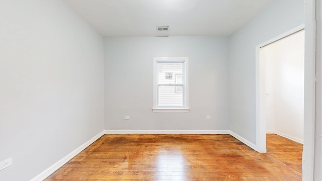 empty room with baseboards, light wood-style floors, and visible vents