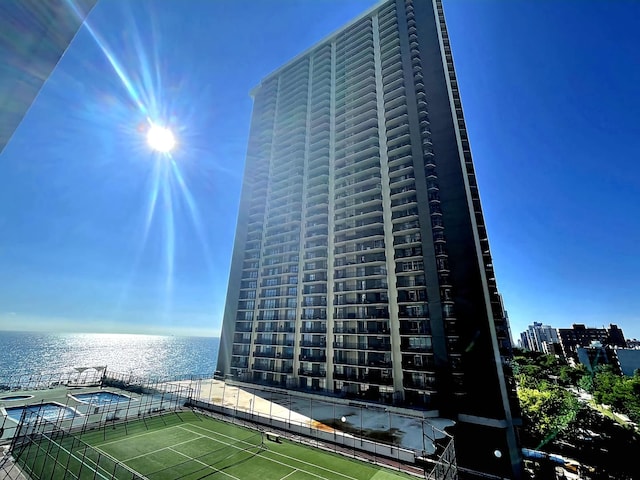 view of building exterior with a water view and a city view