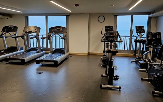 workout area with expansive windows and baseboards