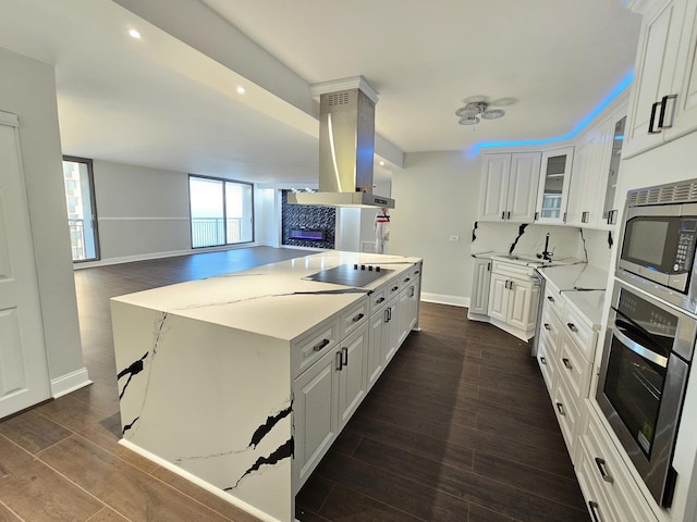 kitchen with stainless steel appliances, island exhaust hood, white cabinetry, and wood tiled floor