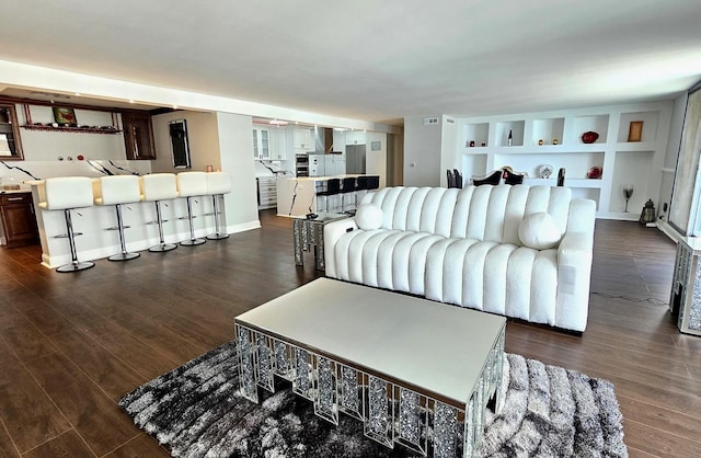 living area featuring dark wood-type flooring and built in features