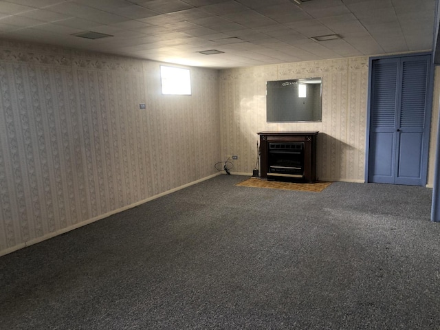 basement featuring carpet floors, baseboards, and wallpapered walls