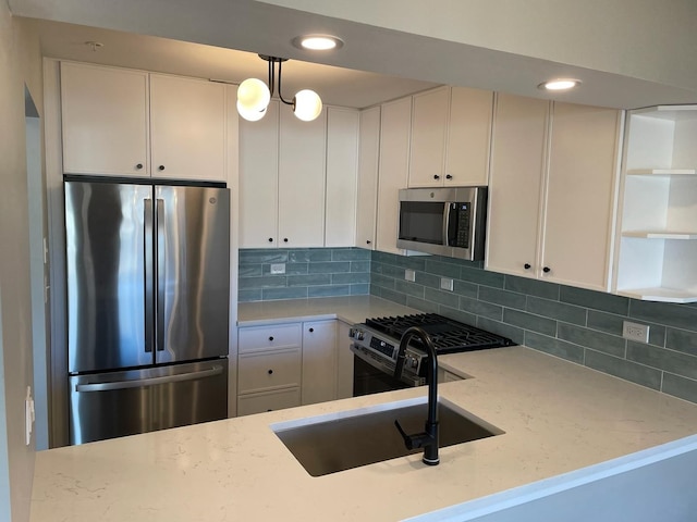 kitchen with appliances with stainless steel finishes, white cabinets, backsplash, and light stone countertops