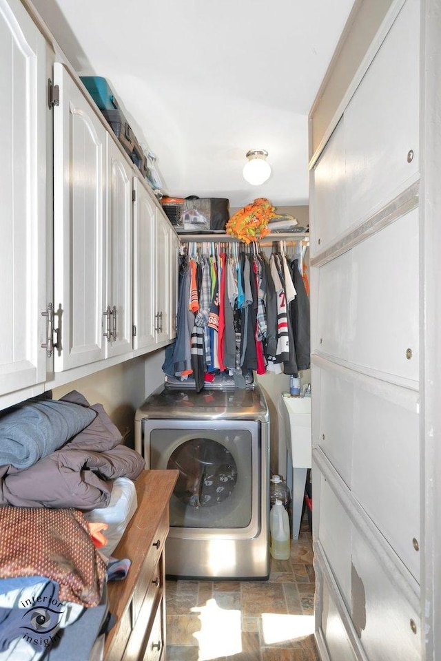 laundry area featuring washer / dryer, stone finish flooring, and laundry area