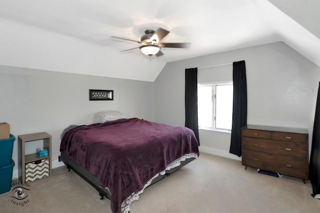 bedroom with a ceiling fan, light carpet, vaulted ceiling, and baseboards