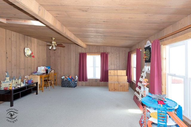 recreation room featuring wooden walls, beam ceiling, and carpet flooring