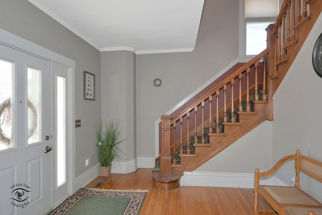 entryway with ornamental molding, stairs, baseboards, and wood finished floors