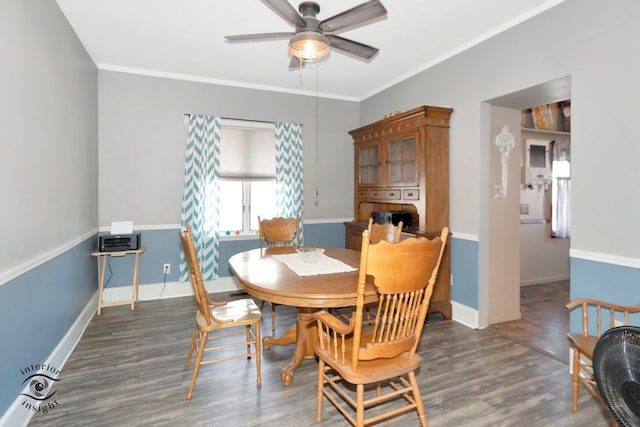 dining room featuring crown molding, baseboards, and wood finished floors