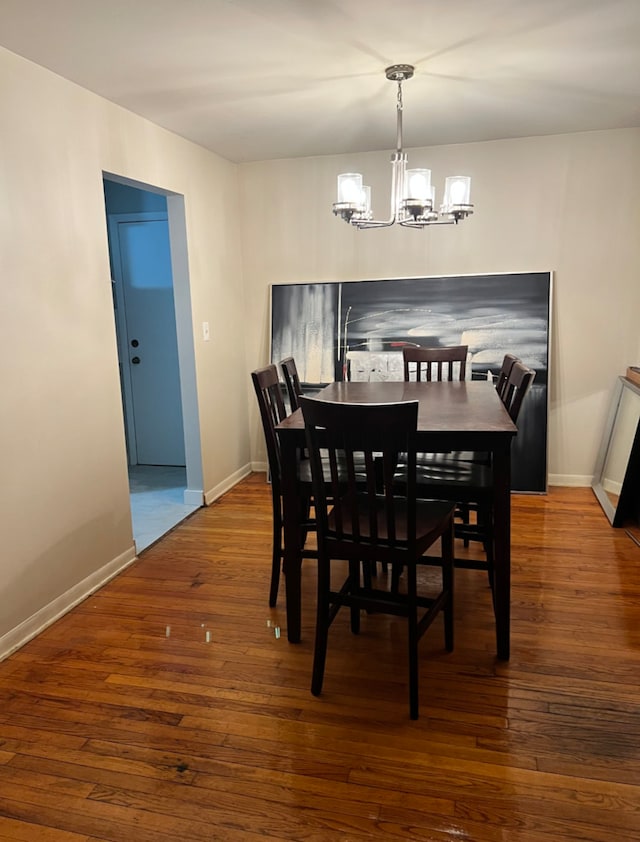 dining room with baseboards, wood-type flooring, and a chandelier