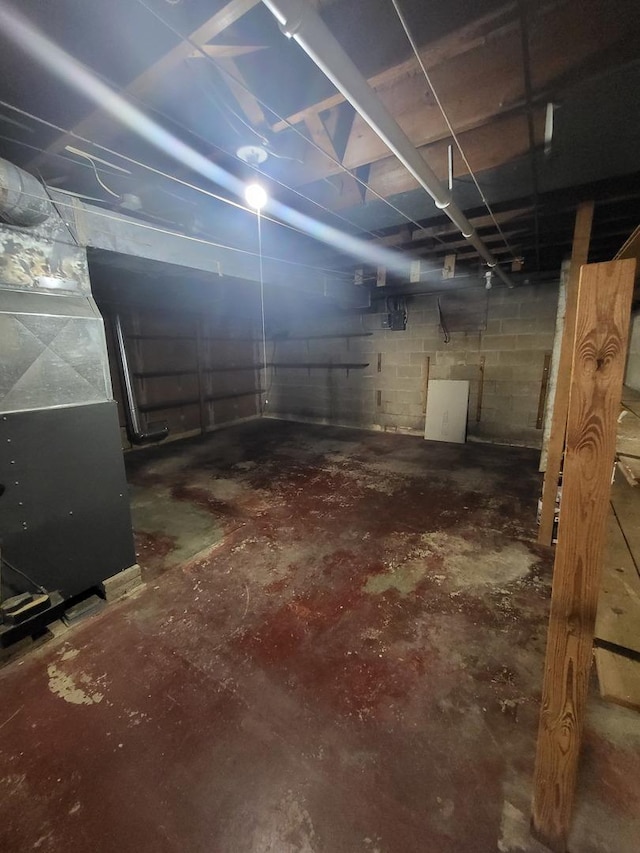 unfinished basement featuring heating unit