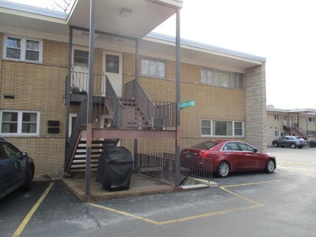 view of property featuring uncovered parking and stairs