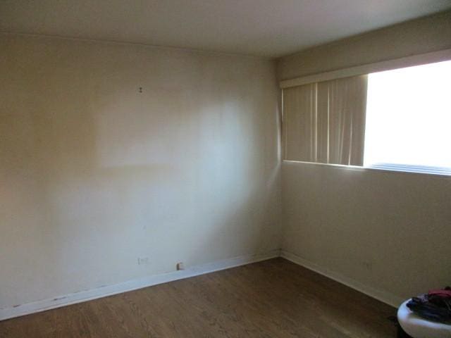 empty room featuring wood finished floors and baseboards