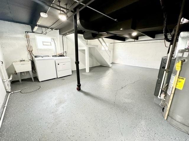 unfinished below grade area featuring independent washer and dryer, a sink, and concrete block wall