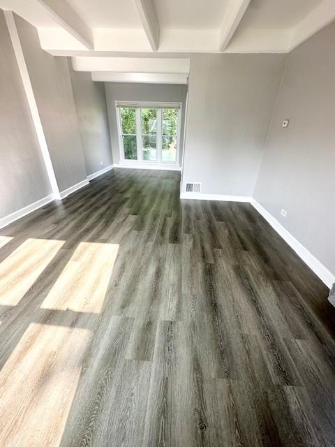 interior space featuring beam ceiling, baseboards, and wood finished floors