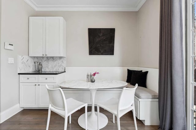 dining area with breakfast area, crown molding, dark wood finished floors, and baseboards