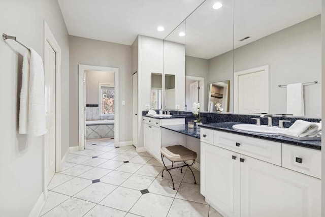 bathroom with a sink, visible vents, baseboards, tile patterned floors, and double vanity