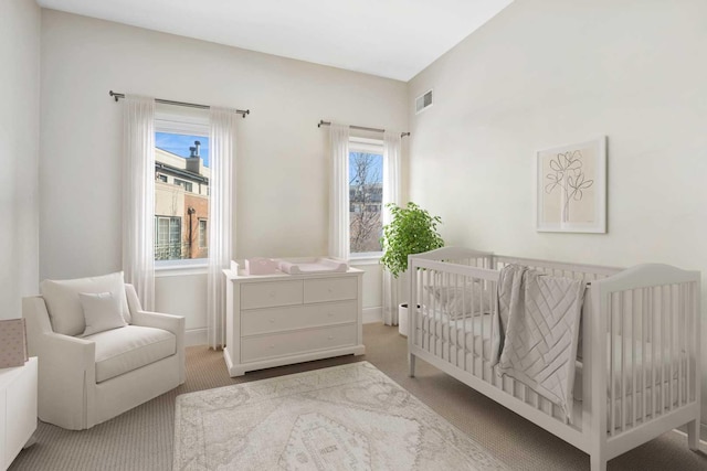 living area featuring baseboards, visible vents, and carpet flooring