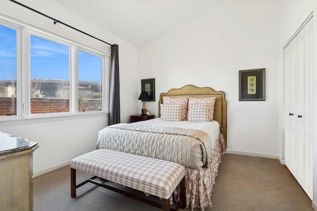 bedroom with lofted ceiling, carpet, baseboards, and a closet