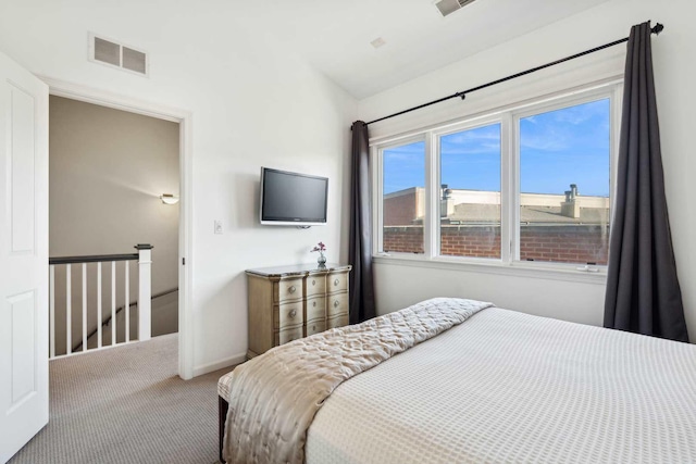 carpeted bedroom with vaulted ceiling, visible vents, and baseboards