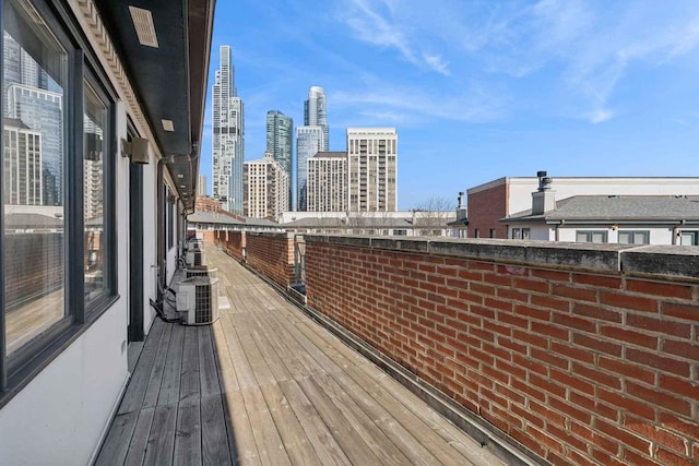 wooden deck featuring a city view and central AC unit