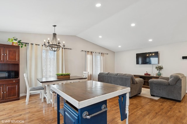 kitchen featuring blue cabinets, light wood-type flooring, black microwave, and vaulted ceiling