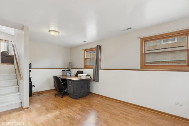 office area featuring a healthy amount of sunlight, visible vents, baseboards, and light wood finished floors