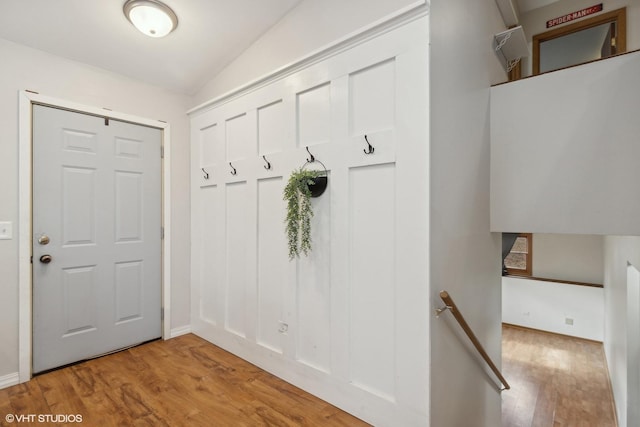 mudroom featuring vaulted ceiling and wood finished floors