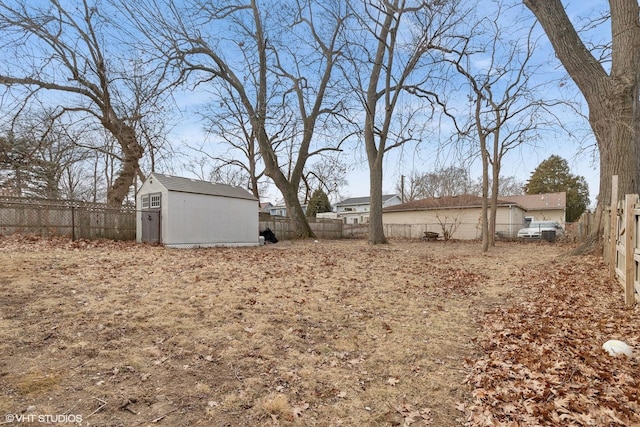 view of yard featuring an outbuilding, a storage unit, and a fenced backyard