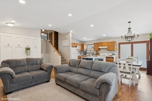 living area with light wood-style flooring, stairs, vaulted ceiling, and recessed lighting