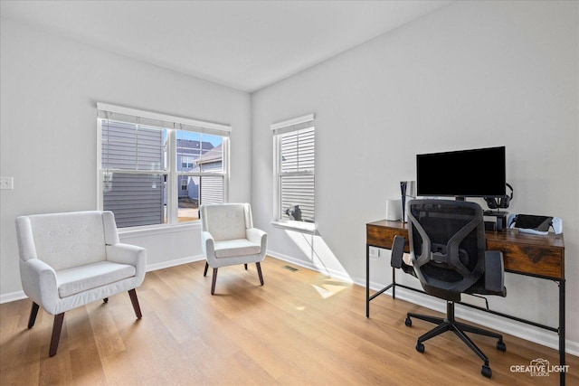 office area featuring light wood-style flooring, visible vents, and baseboards