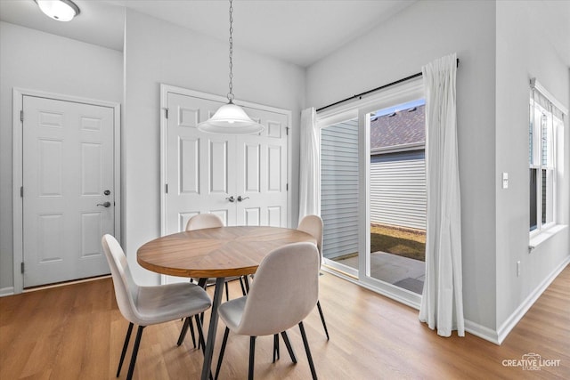 dining space with light wood-style flooring and baseboards