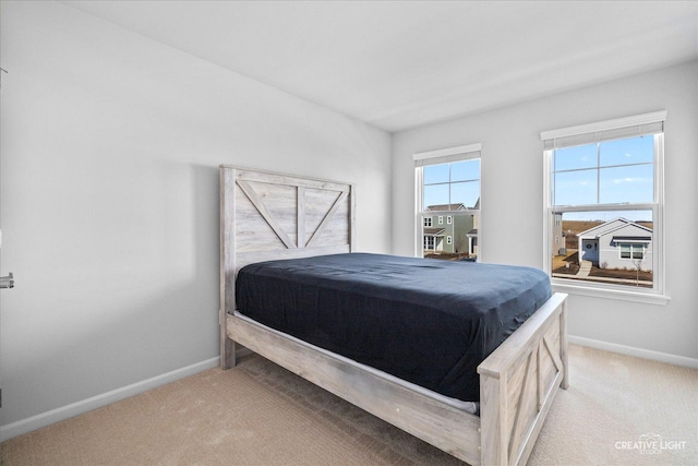 bedroom featuring light carpet and baseboards