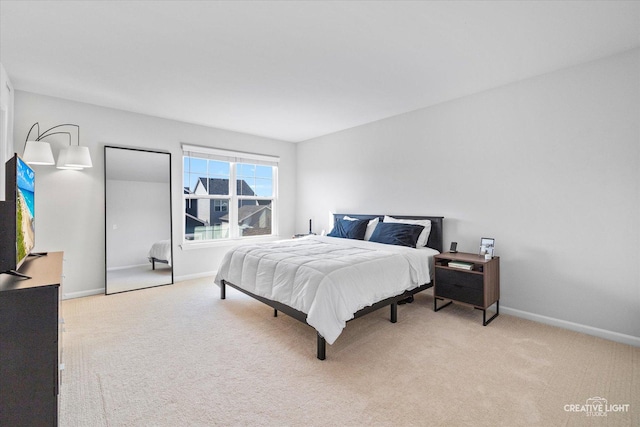 bedroom featuring light colored carpet and baseboards