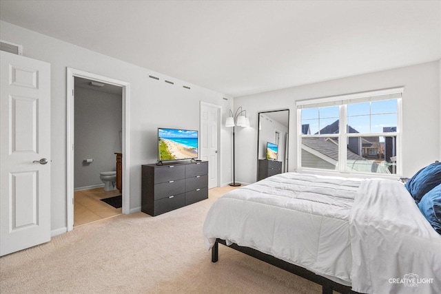 bedroom with baseboards, ensuite bath, visible vents, and light colored carpet