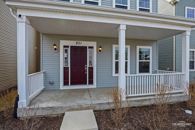 view of exterior entry featuring covered porch