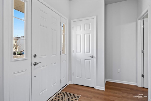 foyer entrance with baseboards and wood finished floors