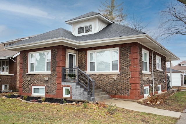 bungalow with roof with shingles and brick siding