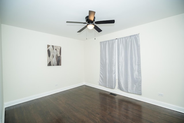 unfurnished room featuring dark wood-style floors, visible vents, ceiling fan, and baseboards