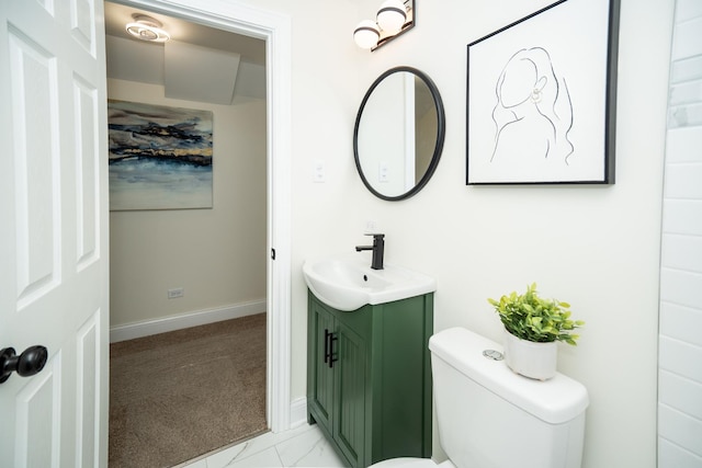 bathroom featuring toilet, marble finish floor, vanity, and baseboards