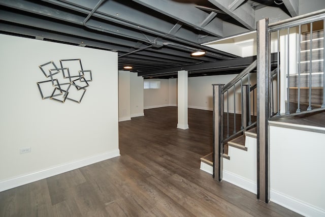 below grade area with wood finished floors, baseboards, and stairs